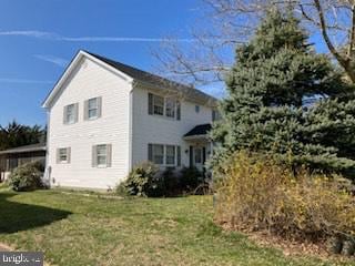 rear view of house featuring a yard