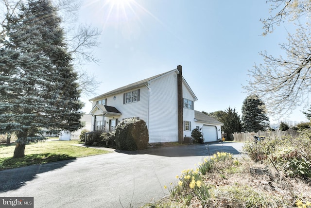 view of side of property with a yard and a garage