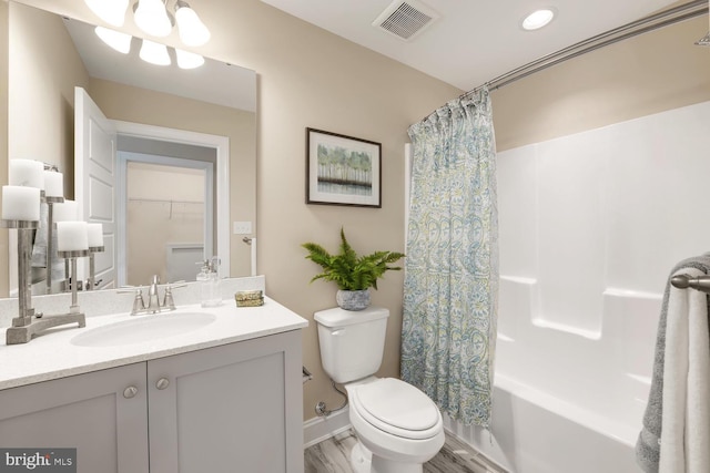 full bathroom featuring hardwood / wood-style floors, vanity, shower / bath combination with curtain, and toilet