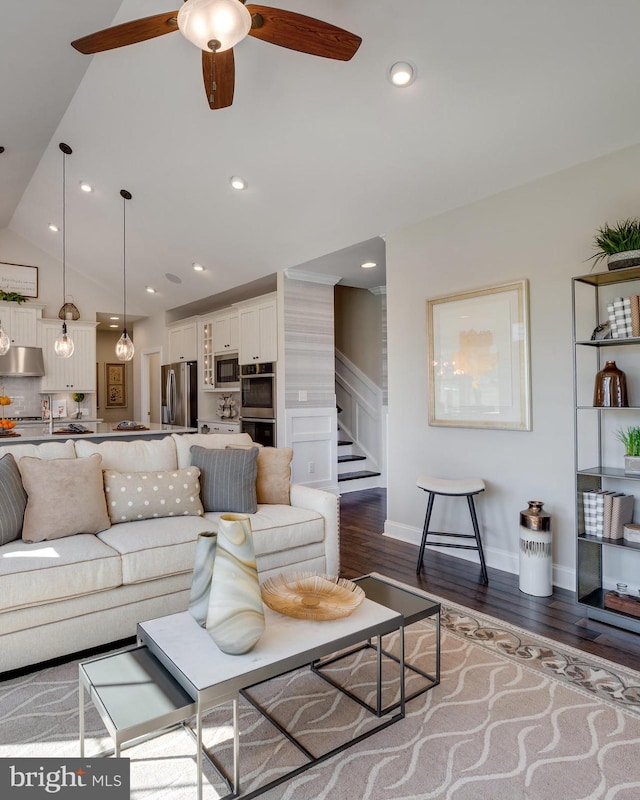 living room featuring vaulted ceiling, ceiling fan, and dark wood-type flooring