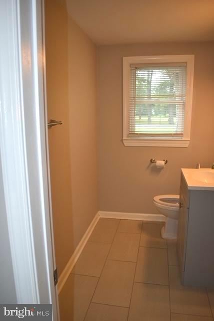 bathroom featuring toilet, tile floors, and vanity