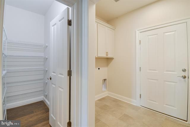 washroom featuring cabinets and light tile floors