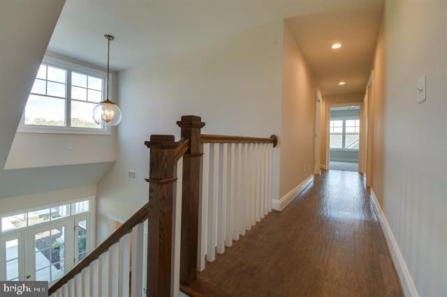 corridor featuring a chandelier, french doors, hardwood / wood-style flooring, and a wealth of natural light