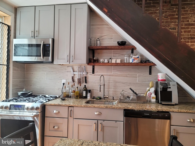 kitchen featuring gray cabinetry, tasteful backsplash, sink, and stainless steel appliances