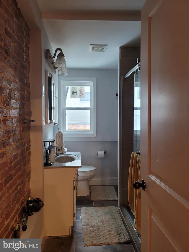 bathroom featuring brick wall, toilet, tile flooring, and vanity