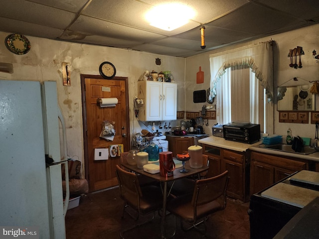 dining space featuring a paneled ceiling and sink