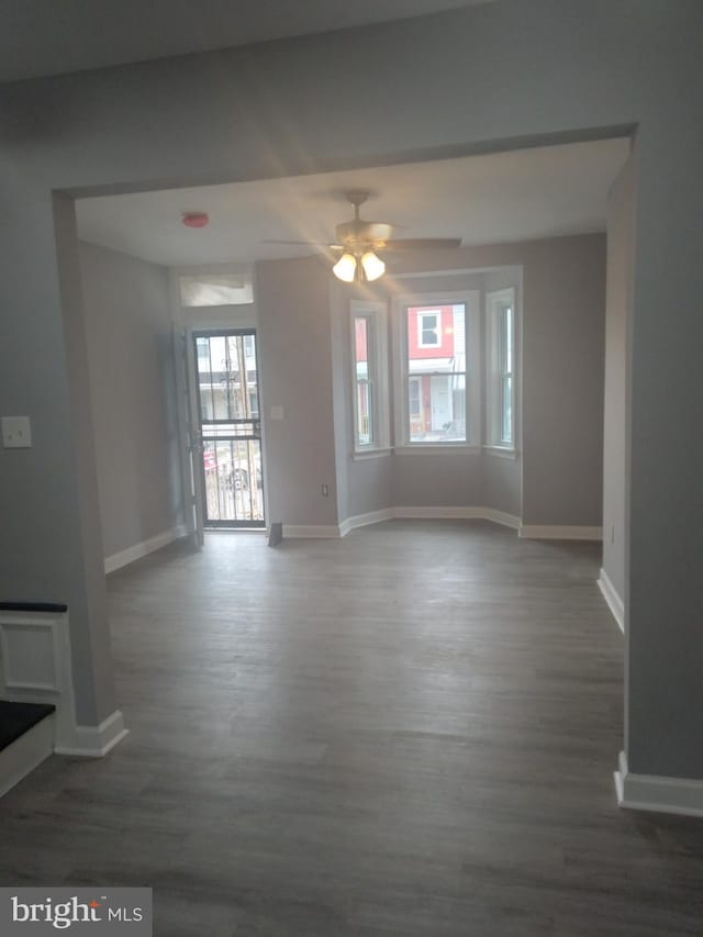 unfurnished room featuring ceiling fan and dark wood-type flooring