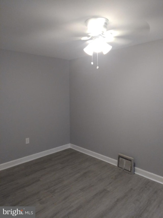 unfurnished room with dark hardwood / wood-style flooring and ceiling fan