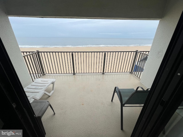 balcony featuring a beach view and a water view