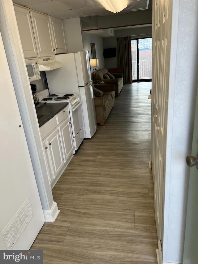 kitchen with premium range hood, light hardwood / wood-style floors, white appliances, and white cabinetry