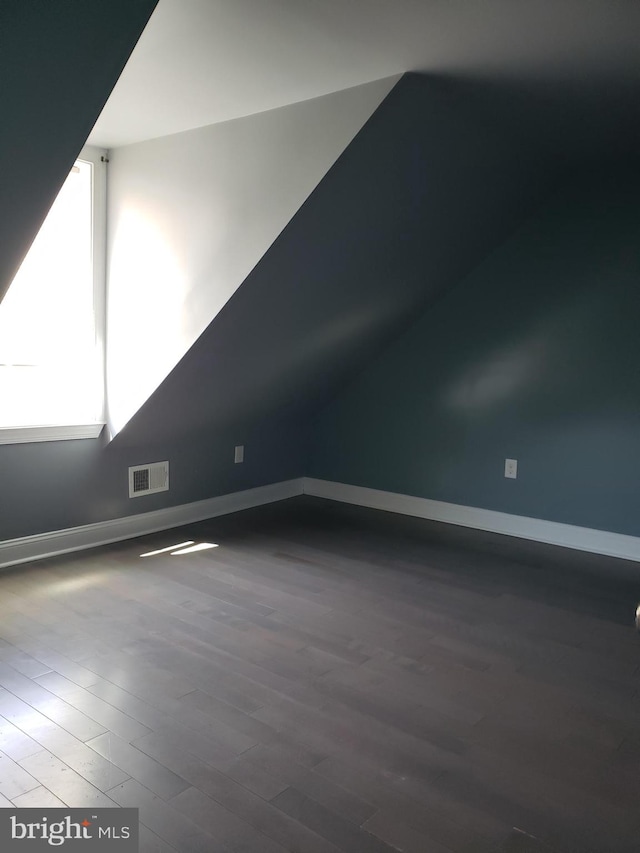 additional living space with dark hardwood / wood-style flooring