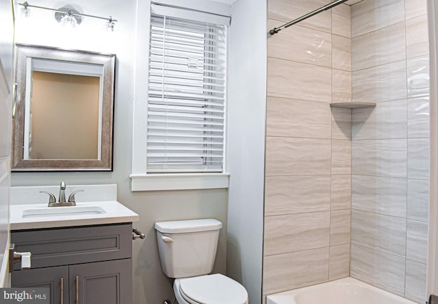 full bathroom with toilet, tiled shower / bath combo, and vanity