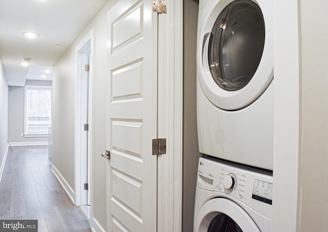 washroom featuring light wood-type flooring and stacked washing maching and dryer