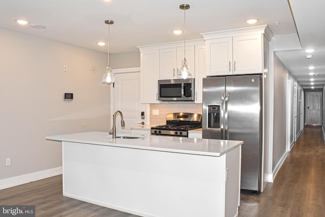 kitchen featuring an island with sink, pendant lighting, dark wood-type flooring, and stainless steel appliances