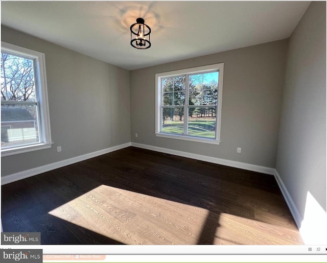 unfurnished room featuring dark hardwood / wood-style flooring and a healthy amount of sunlight