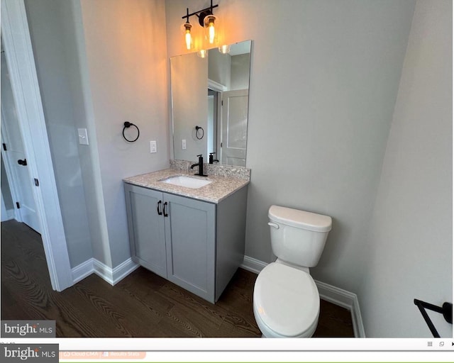 bathroom with oversized vanity, toilet, and hardwood / wood-style flooring