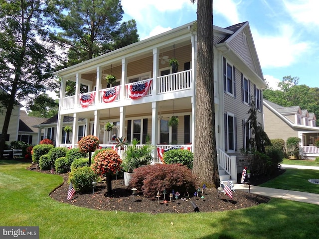 rear view of property featuring a lawn and covered porch