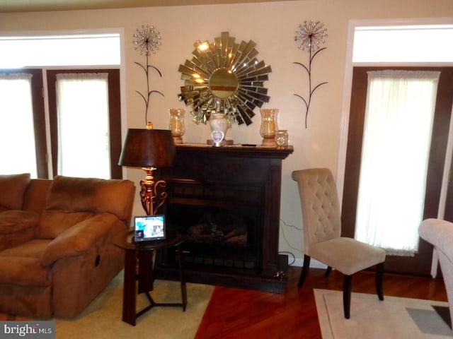 living room with dark hardwood / wood-style flooring, a wealth of natural light, and a chandelier