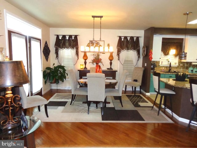 dining area featuring a chandelier, light hardwood / wood-style floors, and sink