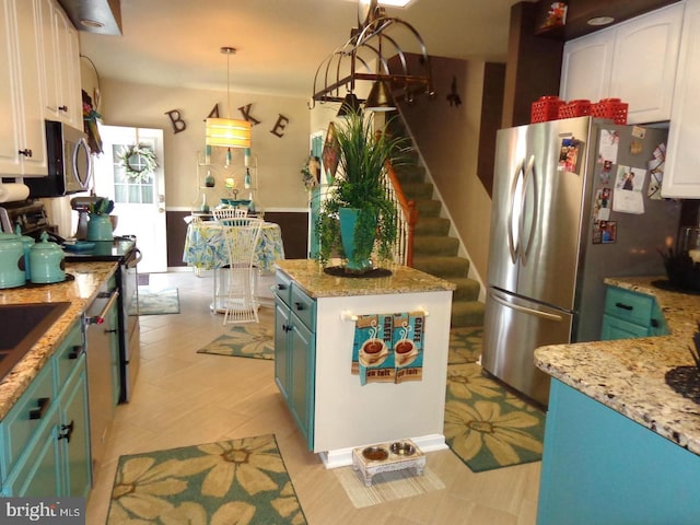 kitchen with decorative light fixtures, blue cabinets, stainless steel appliances, white cabinets, and a kitchen island