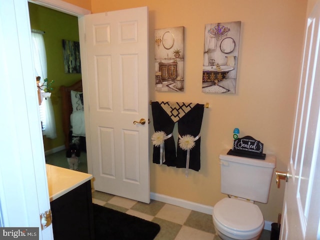 bathroom with tile flooring, toilet, and vanity