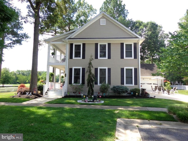 view of front of house with a balcony and a front lawn