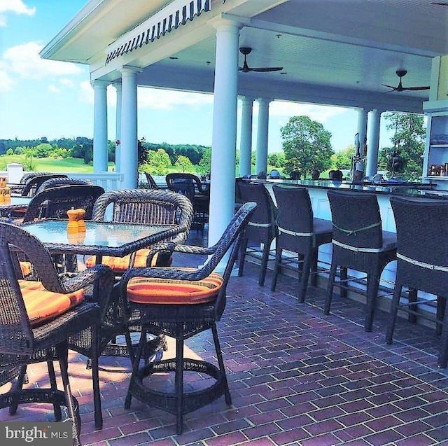 view of patio featuring ceiling fan and exterior bar