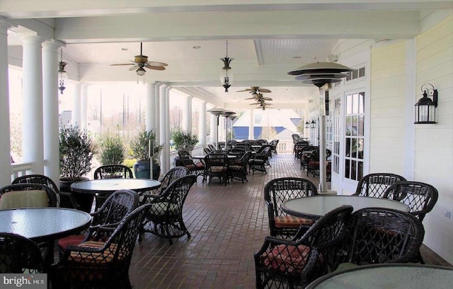 sunroom / solarium with ceiling fan, a wealth of natural light, decorative columns, and beamed ceiling