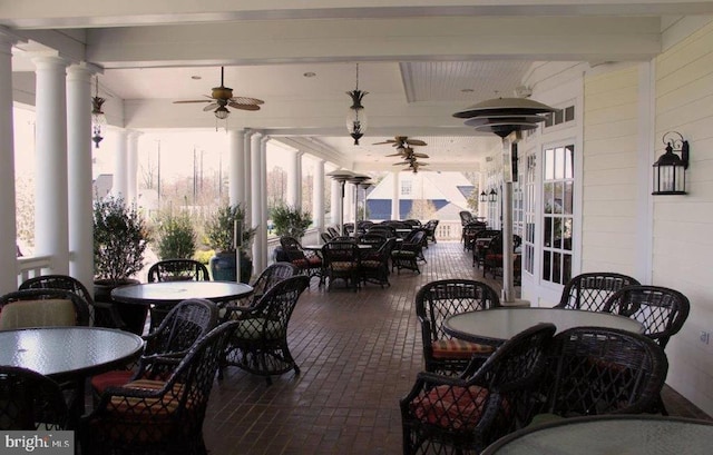 interior space featuring ceiling fan, a wealth of natural light, beam ceiling, and ornate columns