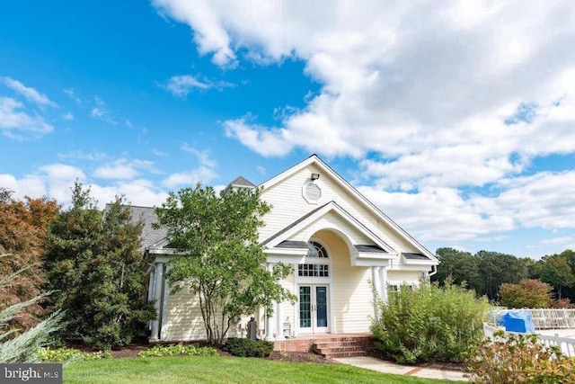 view of front of property featuring a front yard and french doors