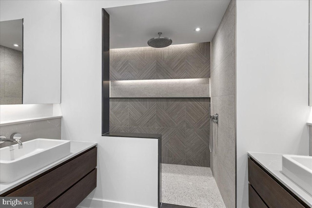 bathroom featuring vanity, a shower, and tile walls