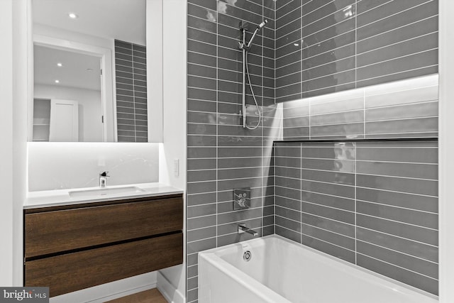 bathroom featuring tiled shower / bath combo and vanity