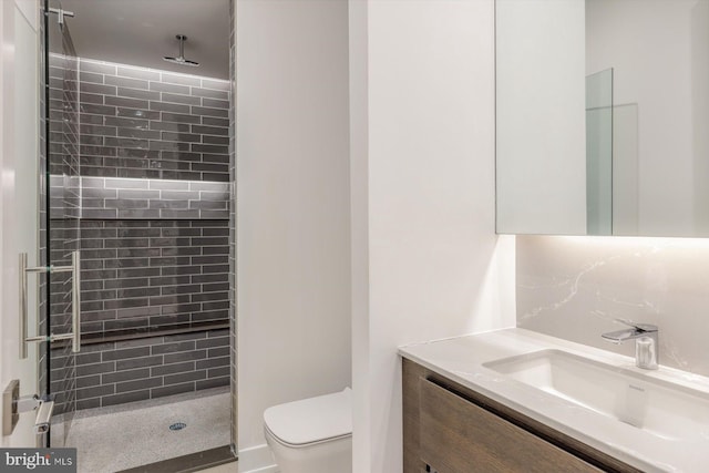 bathroom featuring vanity, toilet, and a shower with door