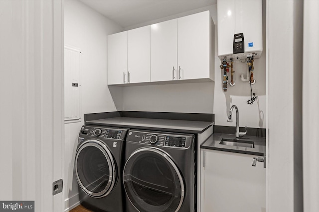 washroom featuring washer and dryer, cabinets, sink, and water heater