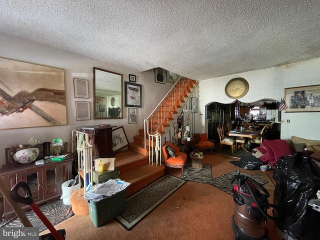 living room featuring a textured ceiling and carpet