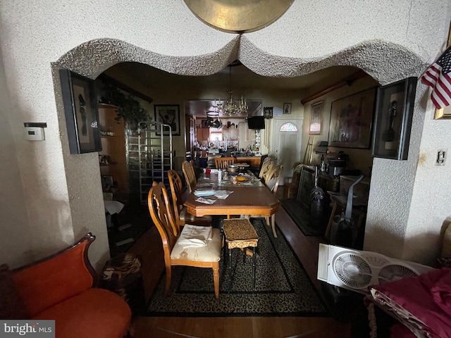 dining space with dark hardwood / wood-style flooring and an inviting chandelier