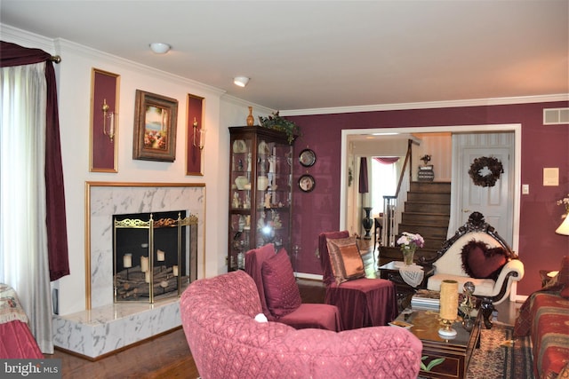 living room featuring a premium fireplace, crown molding, and dark wood-type flooring