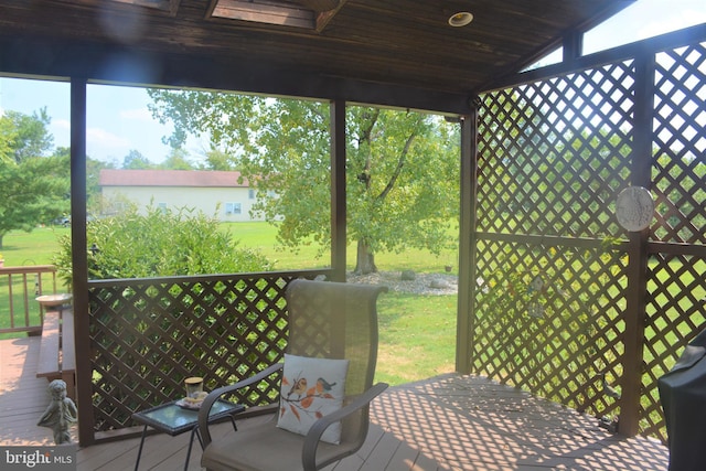 sunroom / solarium featuring lofted ceiling with skylight and wood ceiling