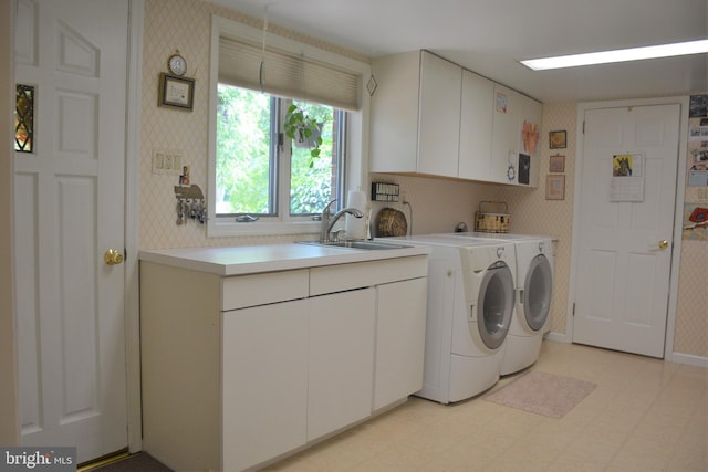 clothes washing area with sink, cabinets, washer and clothes dryer, and light tile floors