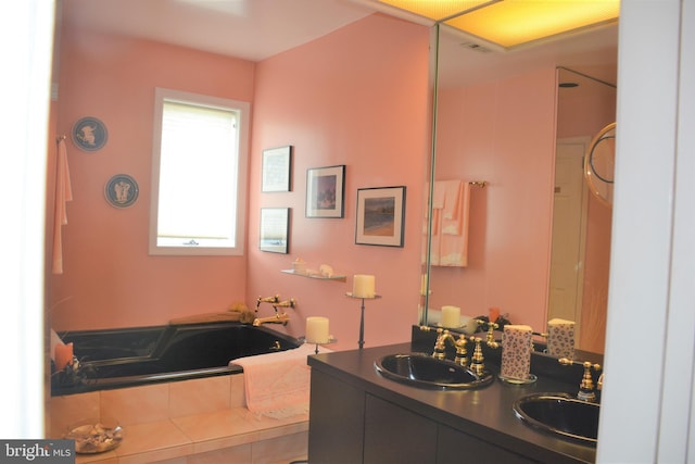 bathroom with dual vanity and tiled tub