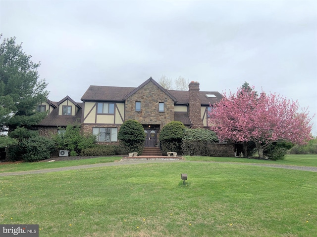 tudor-style house featuring a front yard