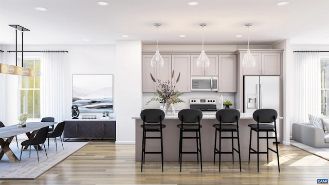 kitchen with appliances with stainless steel finishes, a kitchen island, plenty of natural light, and a kitchen breakfast bar