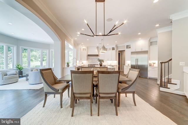 dining area with a notable chandelier, crown molding, and hardwood / wood-style flooring