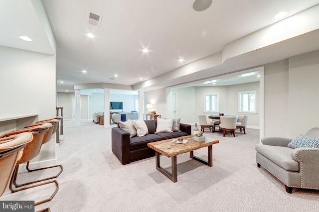 carpeted living room featuring ornate columns