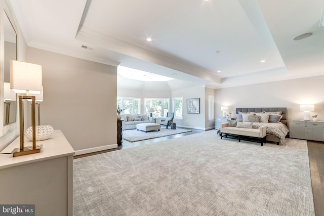 bedroom with crown molding, a raised ceiling, and light colored carpet