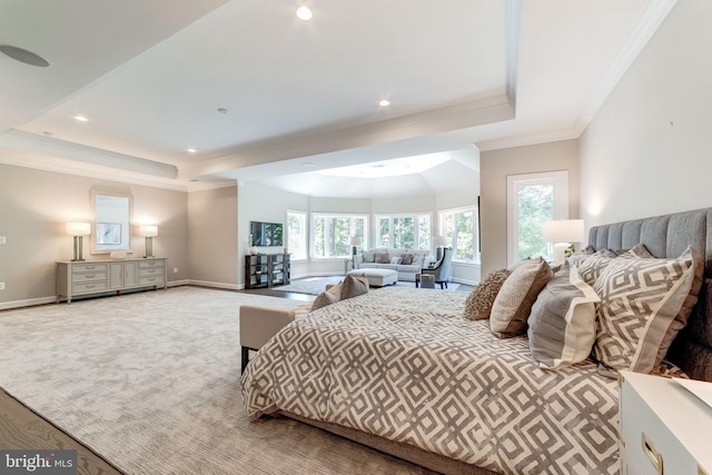 bedroom featuring ornamental molding, light colored carpet, and a tray ceiling