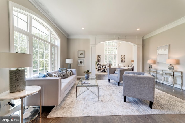 living room featuring ornate columns, light wood-type flooring, and crown molding