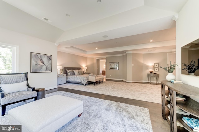 bedroom featuring light hardwood / wood-style floors and a raised ceiling