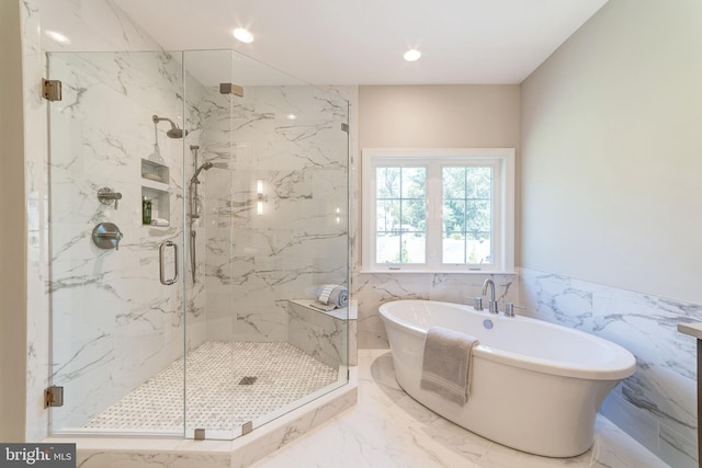 bathroom featuring tile flooring, tile walls, and separate shower and tub