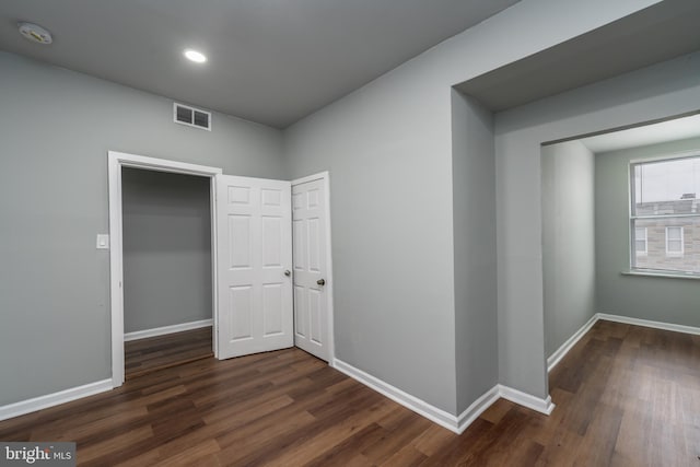 corridor with dark hardwood / wood-style flooring